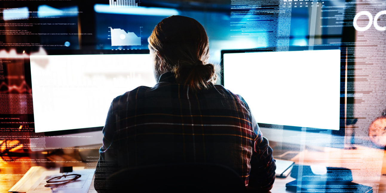 Working hard at it Rearview shot of an unrecognizable male programmer working late at night in the office