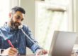 man on phone at computer