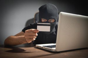 hacker-with-credit-card-laptop-computer-cyber-crime-min